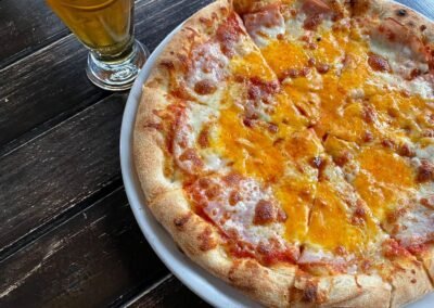 pizza with orange cheese and beer